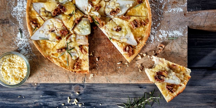 Rustikale Darstellung einer süssen Pizza auf Holzbrett